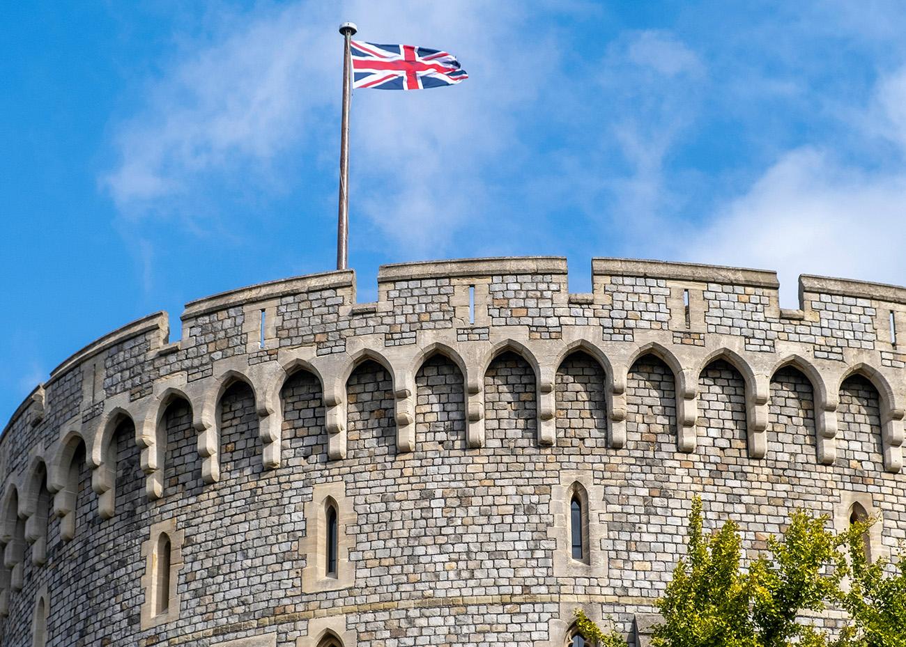 British flag flying at Windsor Castle with blue skies