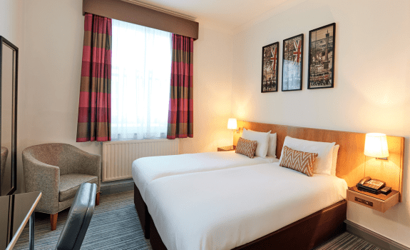 Twin room at thistle bloomsbury park with twin beds desk and armchair