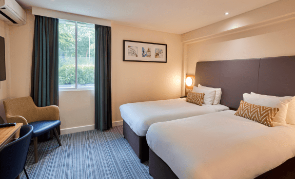 Executive Twin bedroom with two single beds, window view, and modern décor.