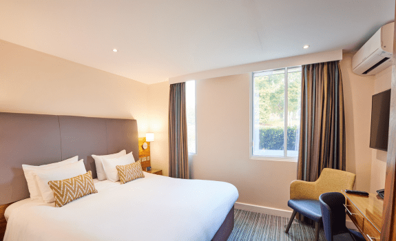 Heathrow hotel room with a large bed, desk, chair