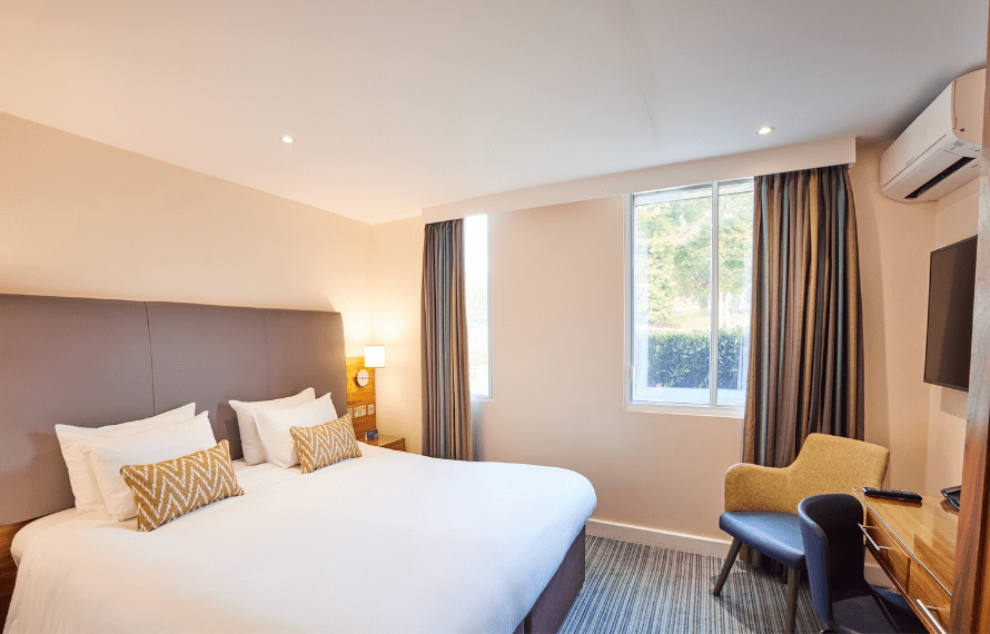 Heathrow hotel room with a large bed, desk, chair