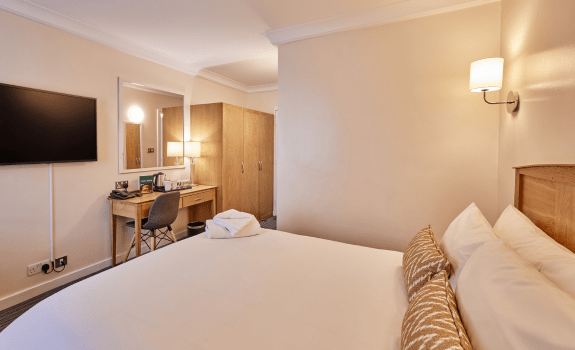 Standard Double bedroom with desk, wardrobe, and wall-mounted TV.