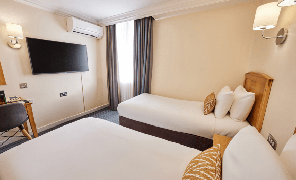 Twin beds in twin room with desk and TV