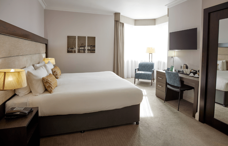 King bed in executive room with TV, desk and bedside tables