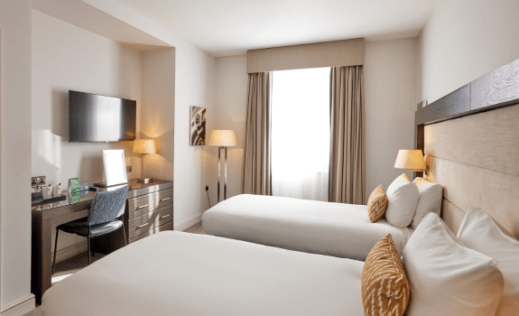 View of the desk and TV area in twin bedroom and window