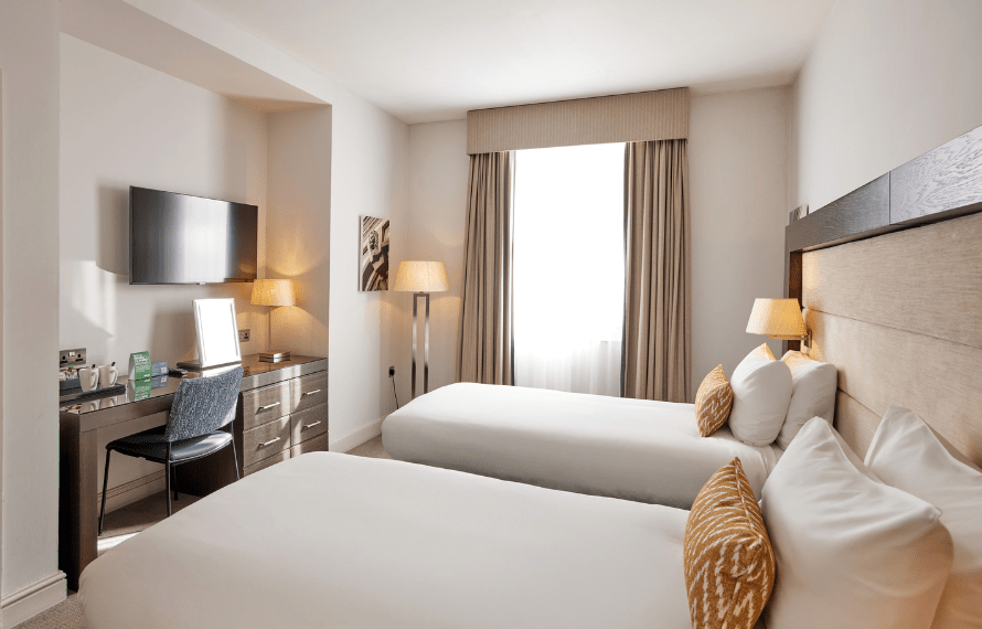 View of the desk and TV area in twin bedroom and window