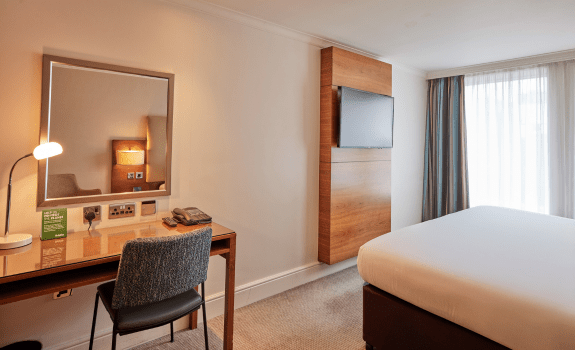 Desk, bed and TV in deluxe king bedroom