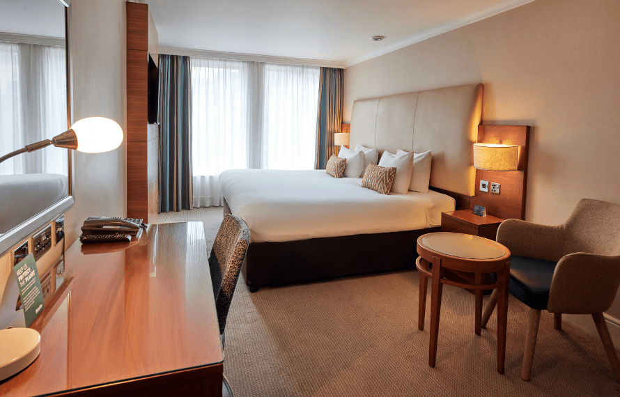 View of deluxe king room with king bed and desk