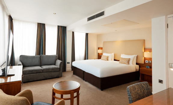Executive king bedroom with bed, sofa and chair