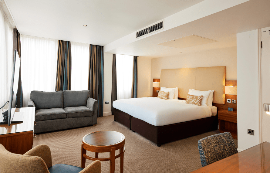 Executive king bedroom with bed, sofa and chair