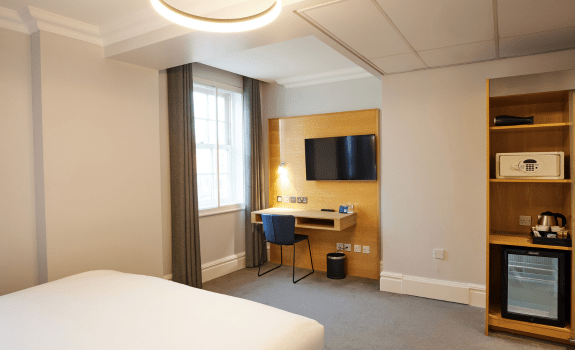 Double bedroom with bed, windows, desk and safe