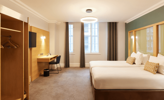 View of twin beds, wardrobe and desk