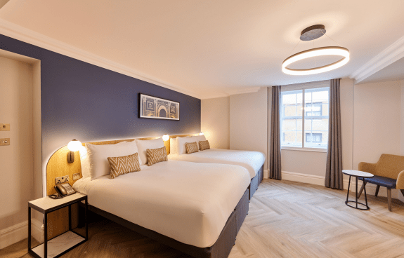 Deluxe family room at Thistle Park Lane with two beds, patterned cushions, wall lighting