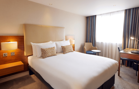 Deluxe Double Garden View room with bed and bedside table