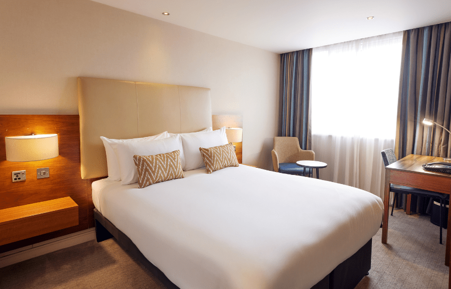 Deluxe Double Garden View room with bed and bedside table